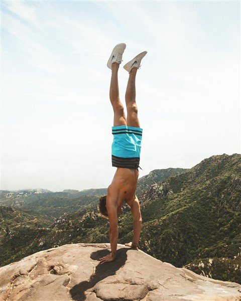 homme musclé debout sur ses mains au bord d'une falaise, pour illustrer ce qu'il est possible de réaliser avec un CV musclé au lieu d'un faux cv