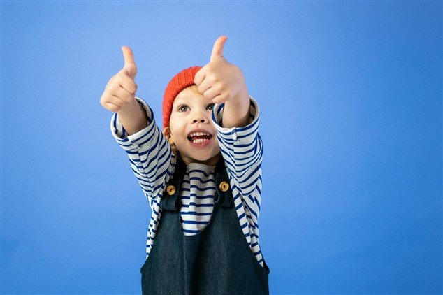 petite fille qui a les deux pouces en l'air pour illustrer l'approbation comme lorsqu'une référence professionnelle recommande quelqu'un