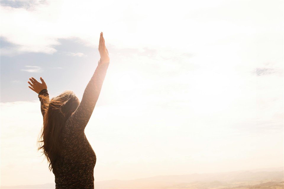 photo d'une femme levant les bras en l'air en signe de libération pour illustrer comment quitter son travail suite à un burnout et percevoir les allocations chômage