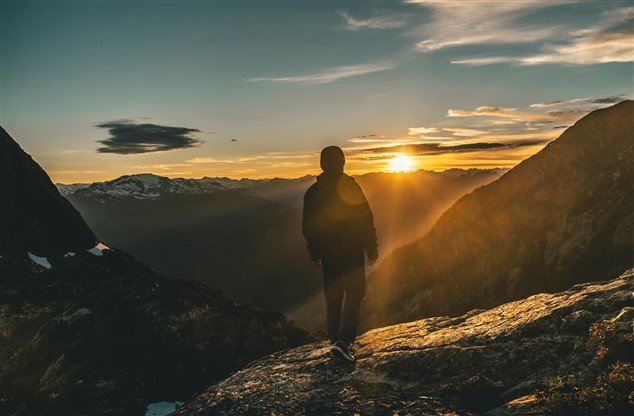 photo d'un homme sur une montagne regardant à l'horizon pour illustrer les nouvelles perspectives qui s'ouvrent après avoir quitté son travail en percevant le chômage