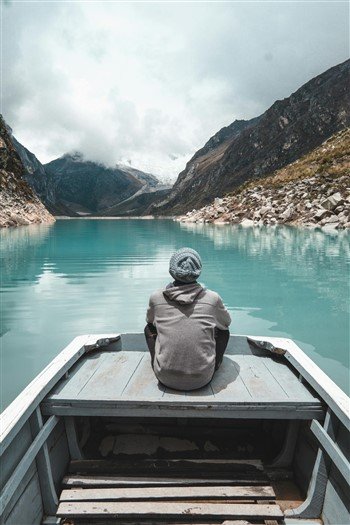 photo d'une personne assise sur une barque regardant au loin pour symboliser les nouvelles perspectives en quittant son travail suite à un burnout en percevant les allocations chômage